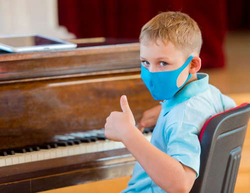 Boy in mask plays piano
