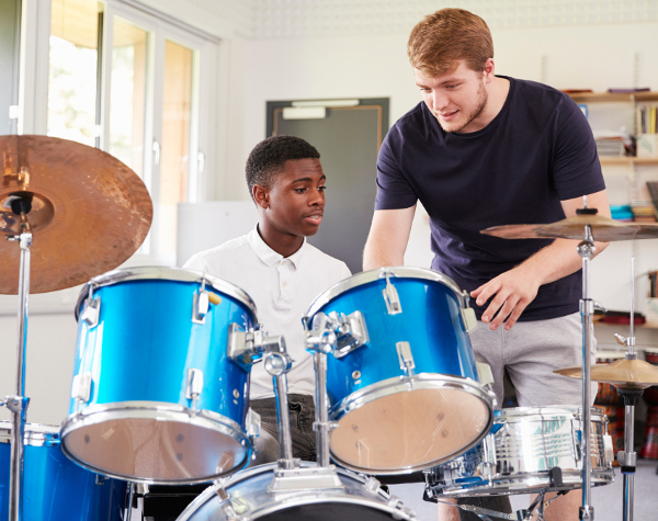 Teacher instructs student on drums